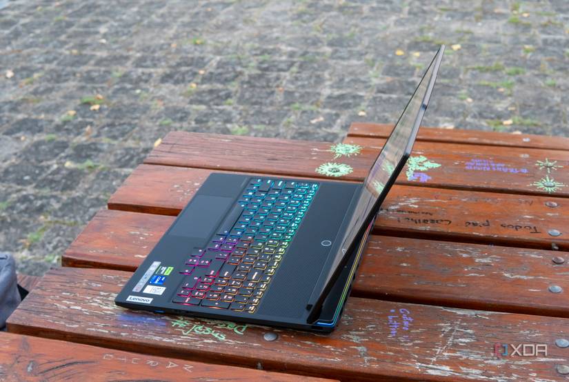 Angled right-side view of the Lenovo Legion 9i on a wooden table with RGB lighting enabled