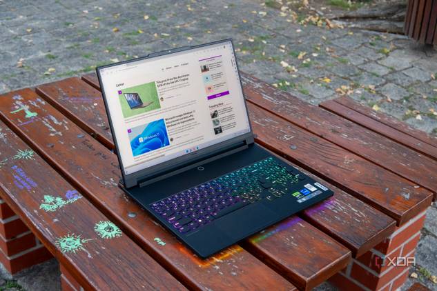 A Lenovo Legion 9i laptop on a wooden table, displaying the XDA homepage