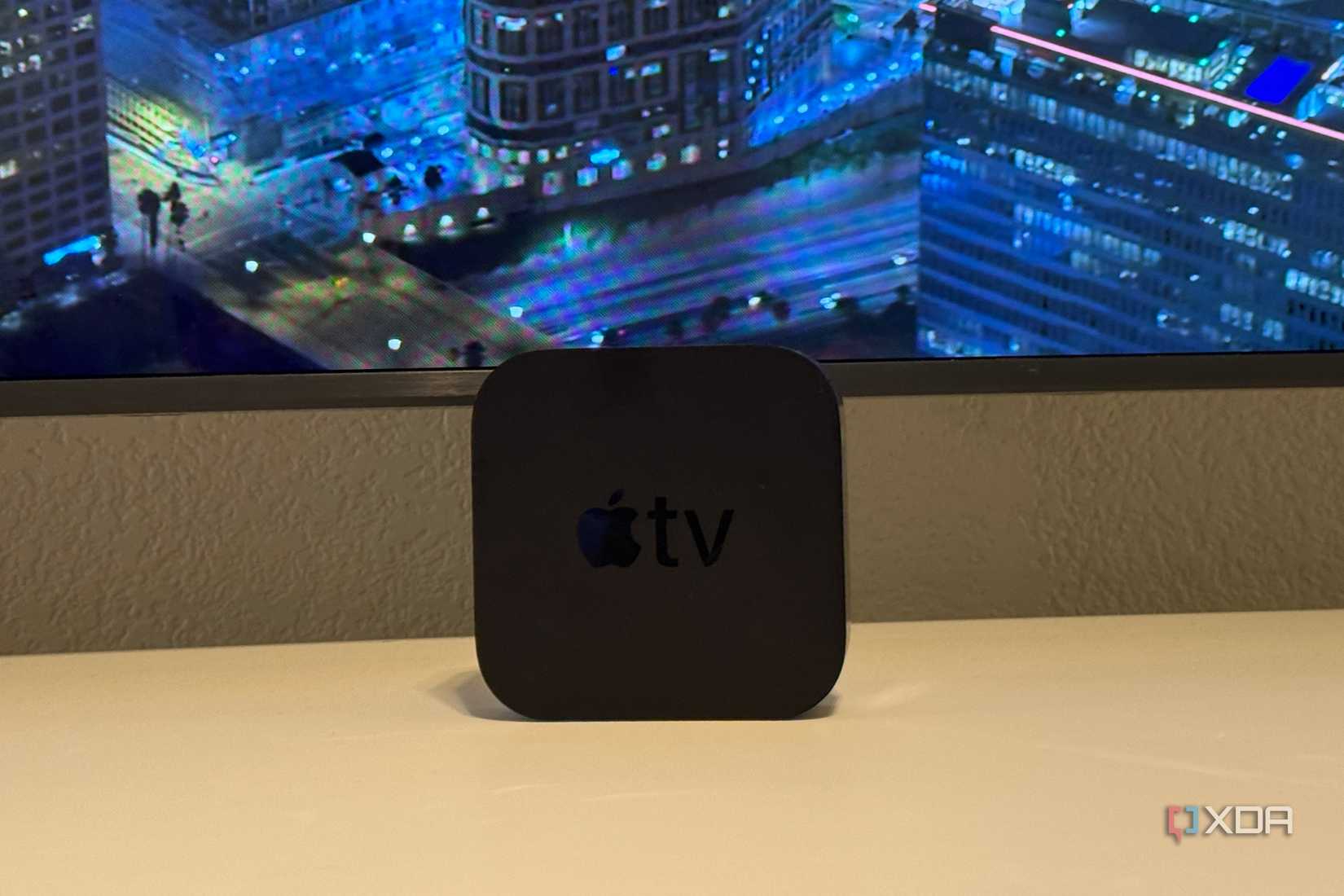 Un Apple TV 4K en un escritorio frente a un televisor.