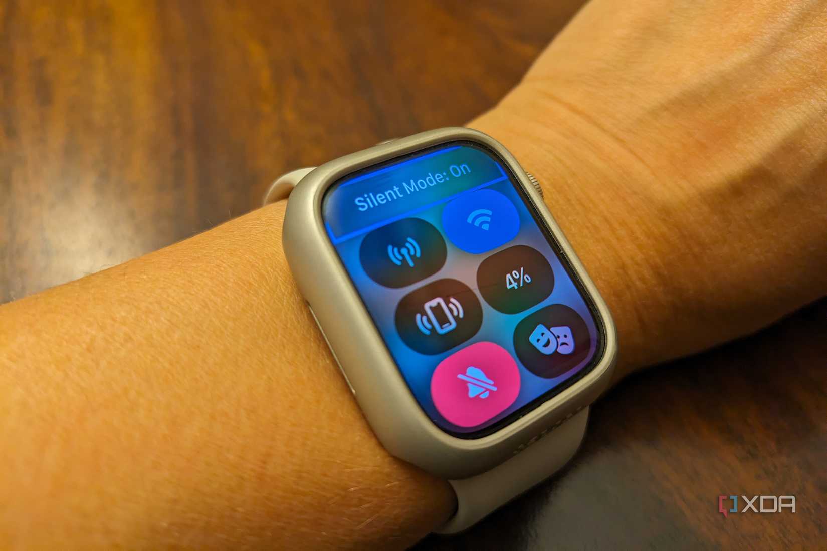 An Apple Watch on a wrist with Control Center open and Silent Mode showing as on.