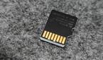 An image showing the back side of a microsd card kept on a felt deskmat.