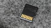 An image showing the back side of a microsd card kept on a felt deskmat.