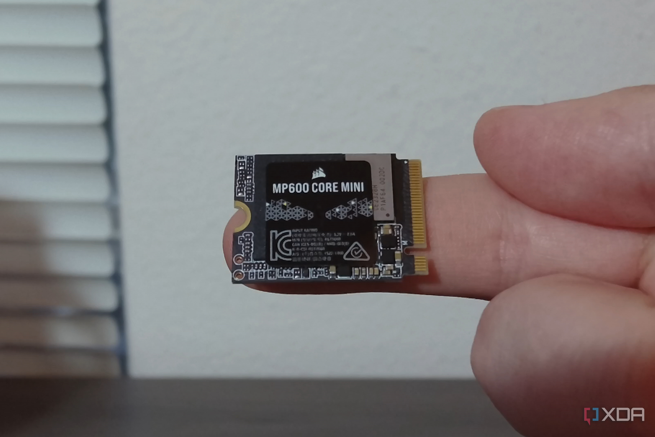Corsair MP600 Core Mini SSD on a finger.