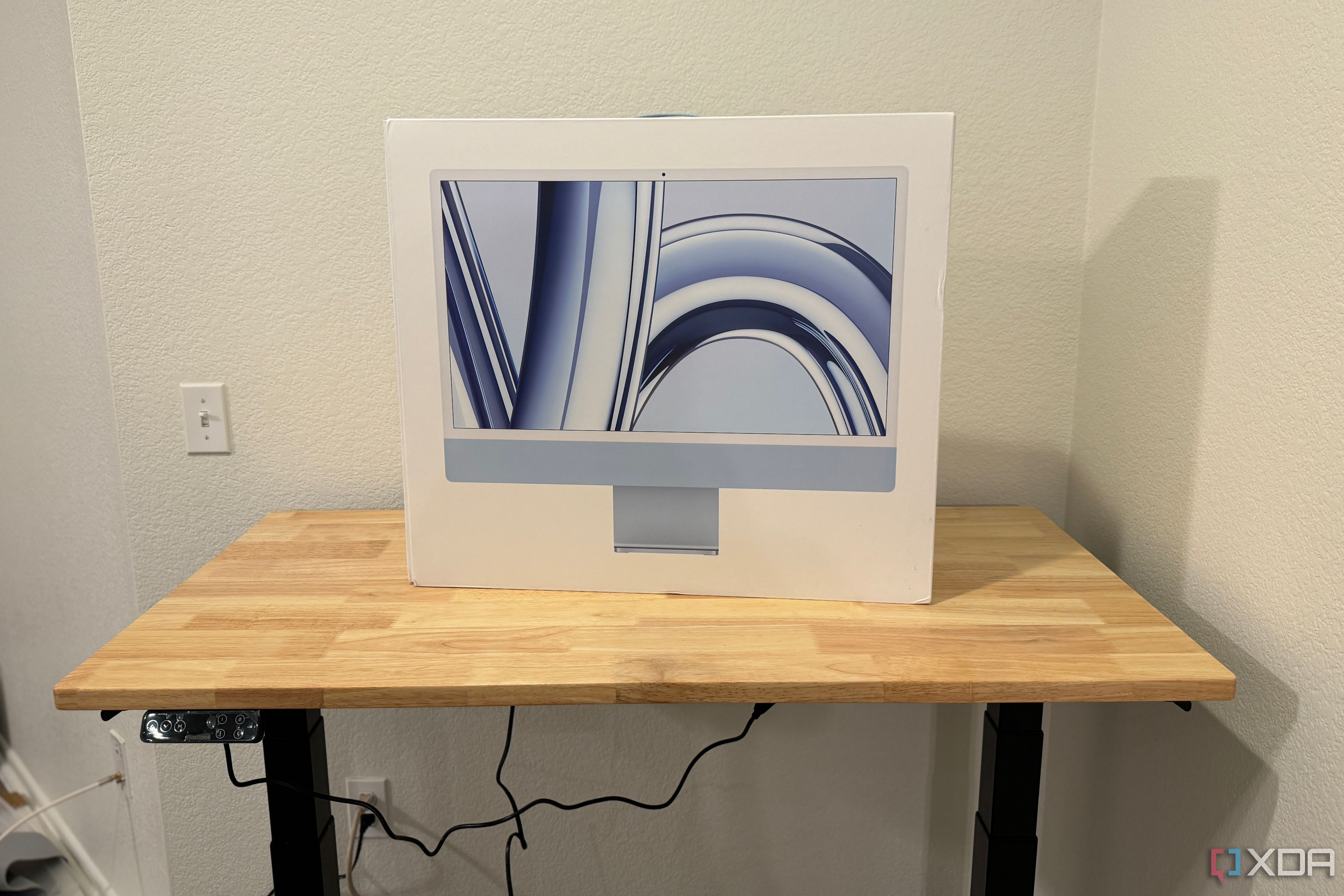 The built FlexiSpot E7 Pro standing desk with an iMac box on top.