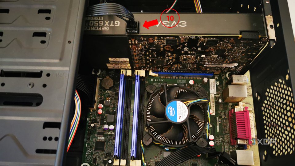 An inside view of a computer case showing a graphics card with a power connector and a label indicating the final step of the process.
