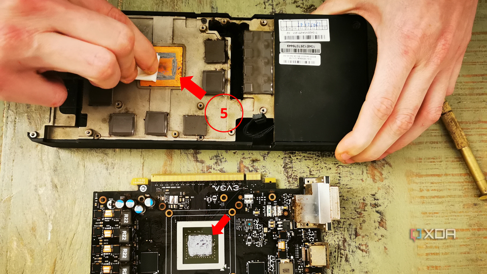 A hand cleaning thermal paste off the heatsink, with a label indicating step five of the process.