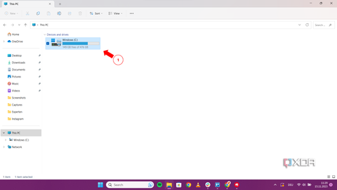 A screenshot of the "This PC" window showing the Windows (C:) drive with a red arrow pointing to the storage space.