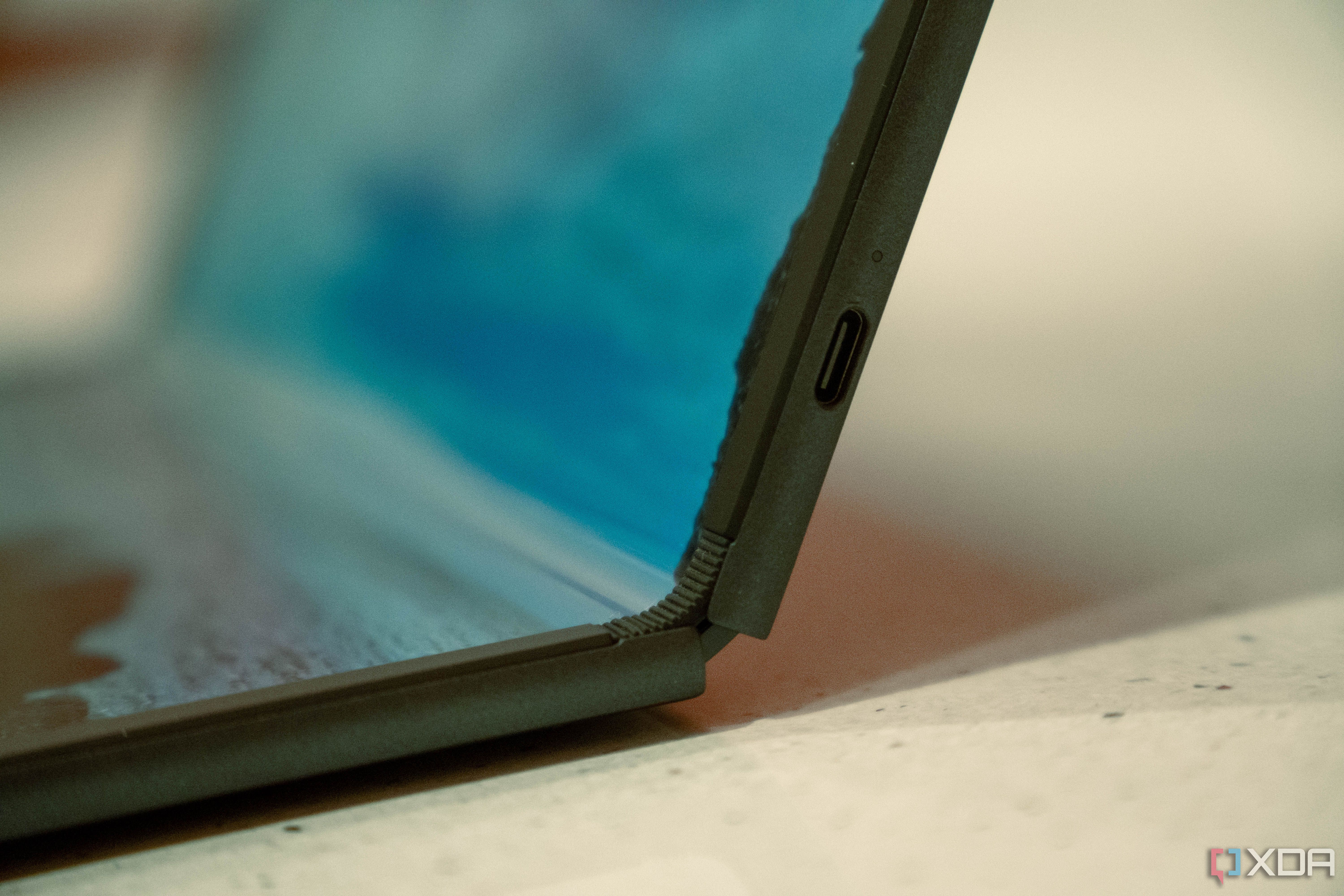Close up of USB-C port on the side of a laptop with a foldable screen, partially folded