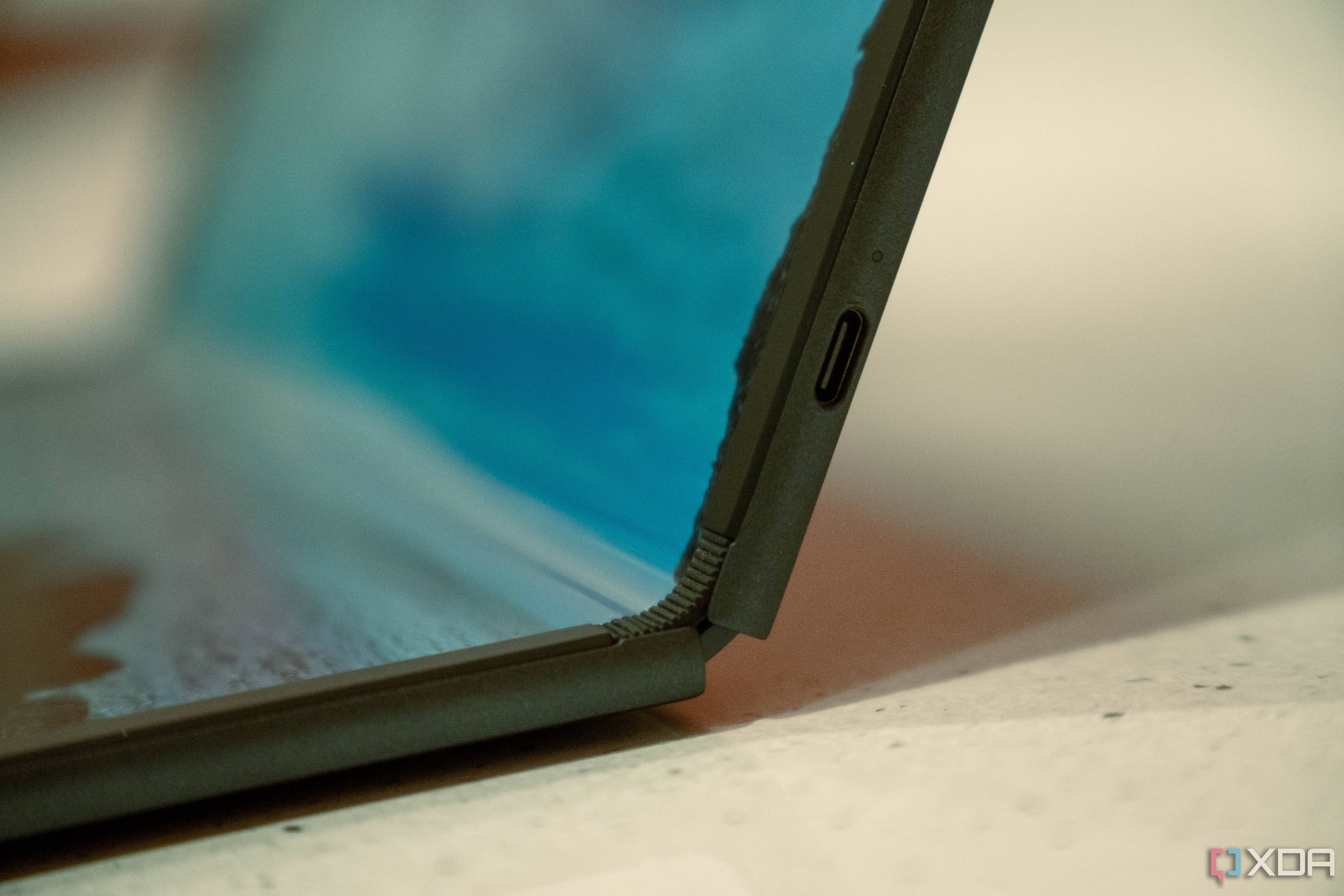 Close up of USB-C port on the side of a laptop with a foldable screen, partially folded