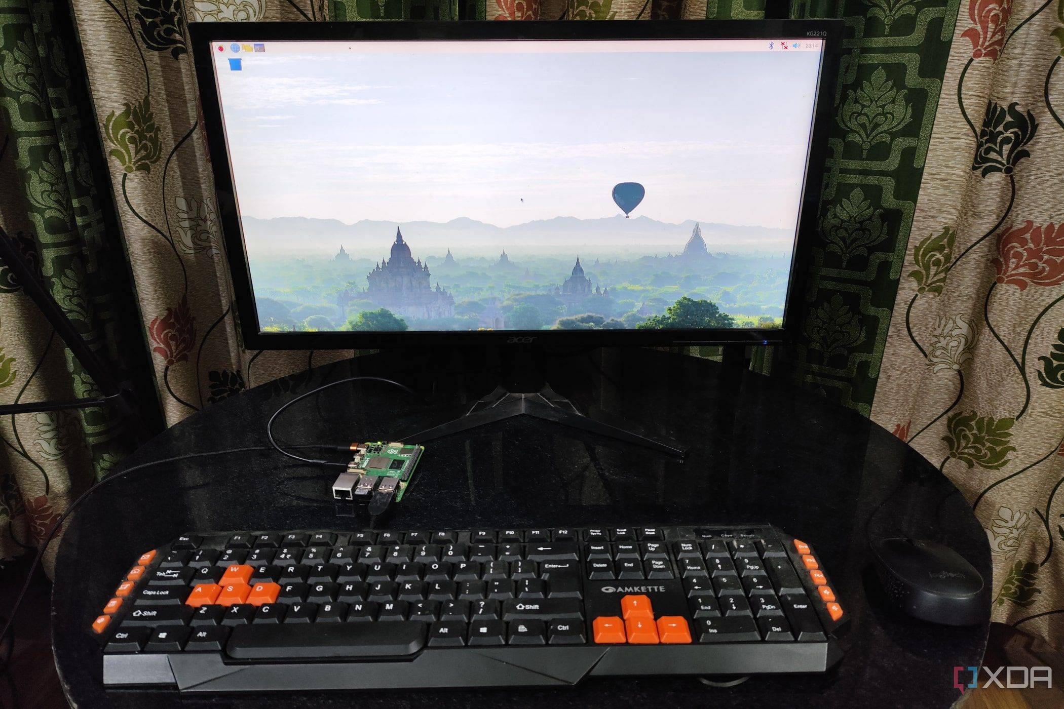 A Raspberry Pi 5 with a keyboard and mouse plugged in, the monitor displaying the Raspberry Pi operating system desktop