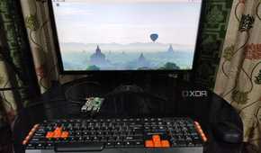 A Raspberry Pi 5 with a keyboard and mouse plugged in, with the monitor displaying the Raspberry Pi OS desktop
