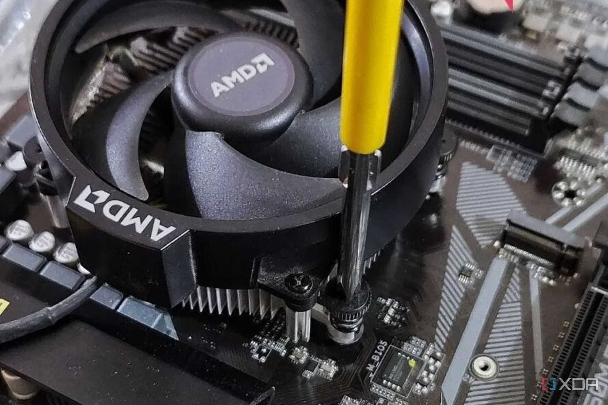 An image showing a CPU fan being screwed onto a motherboard.