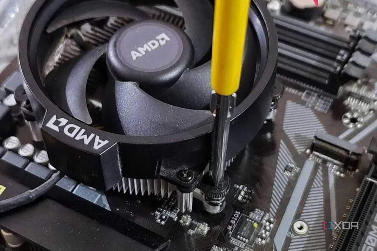 An image showing a CPU fan being screwed onto a motherboard.