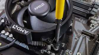An image showing a CPU fan being screwed onto a motherboard.