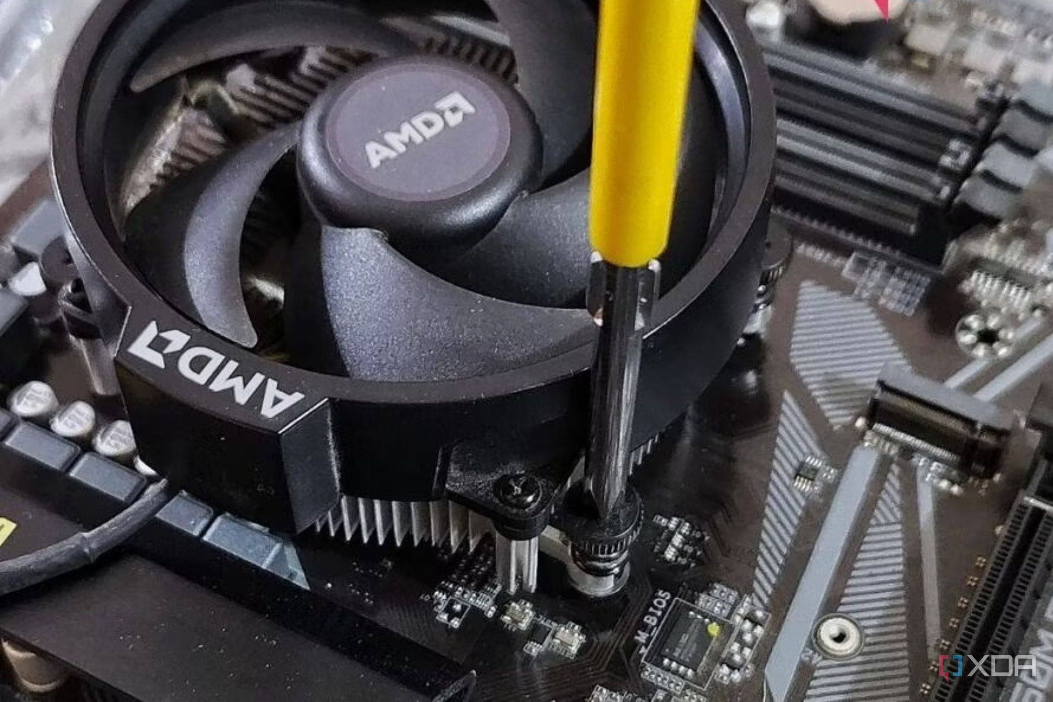 An image showing a CPU fan being screwed onto a motherboard.