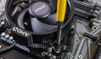 An image showing a CPU fan being screwed onto a motherboard.