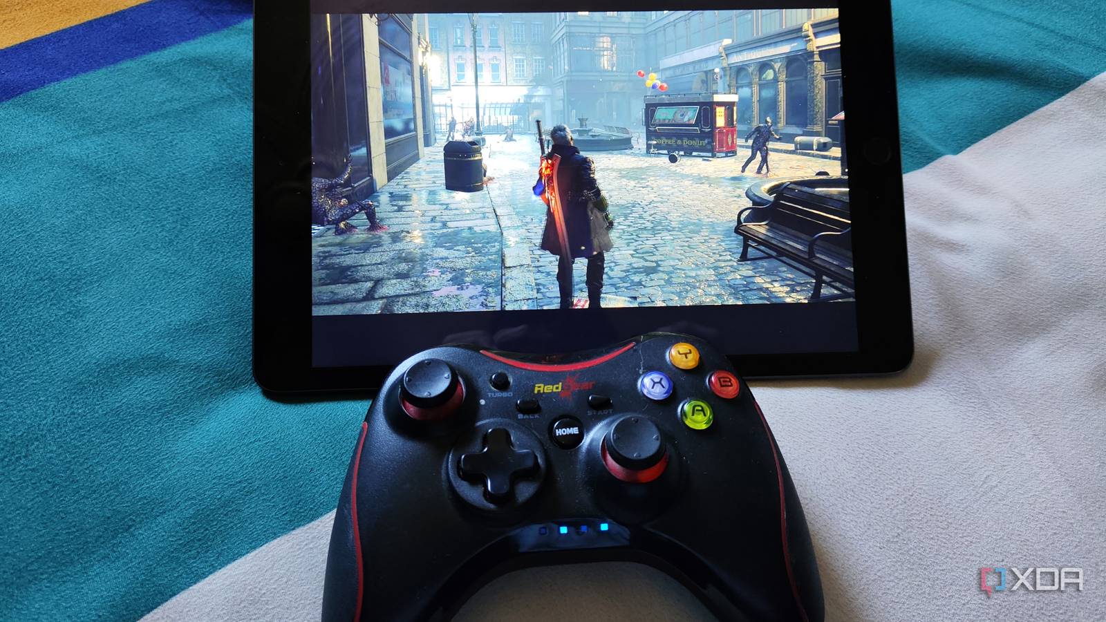 An image of an iPad running Devil May Cry 5 with a RedGear controller nearby