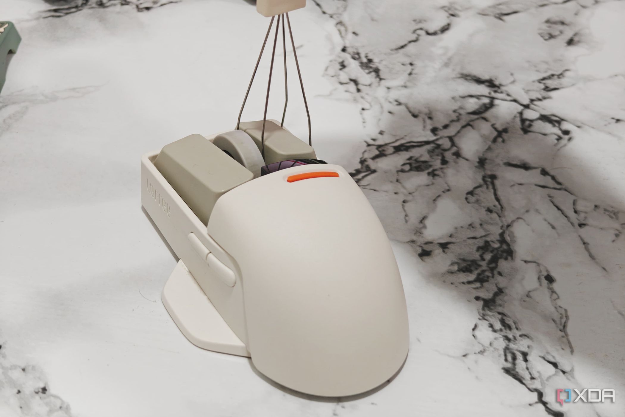 An image showing a keycap puller being used on a Lofree PBT wireless mouse.