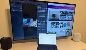 A MacBook Air on a desk connected to an Apple TV.