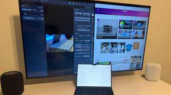 A MacBook Air on a desk connected to an Apple TV.