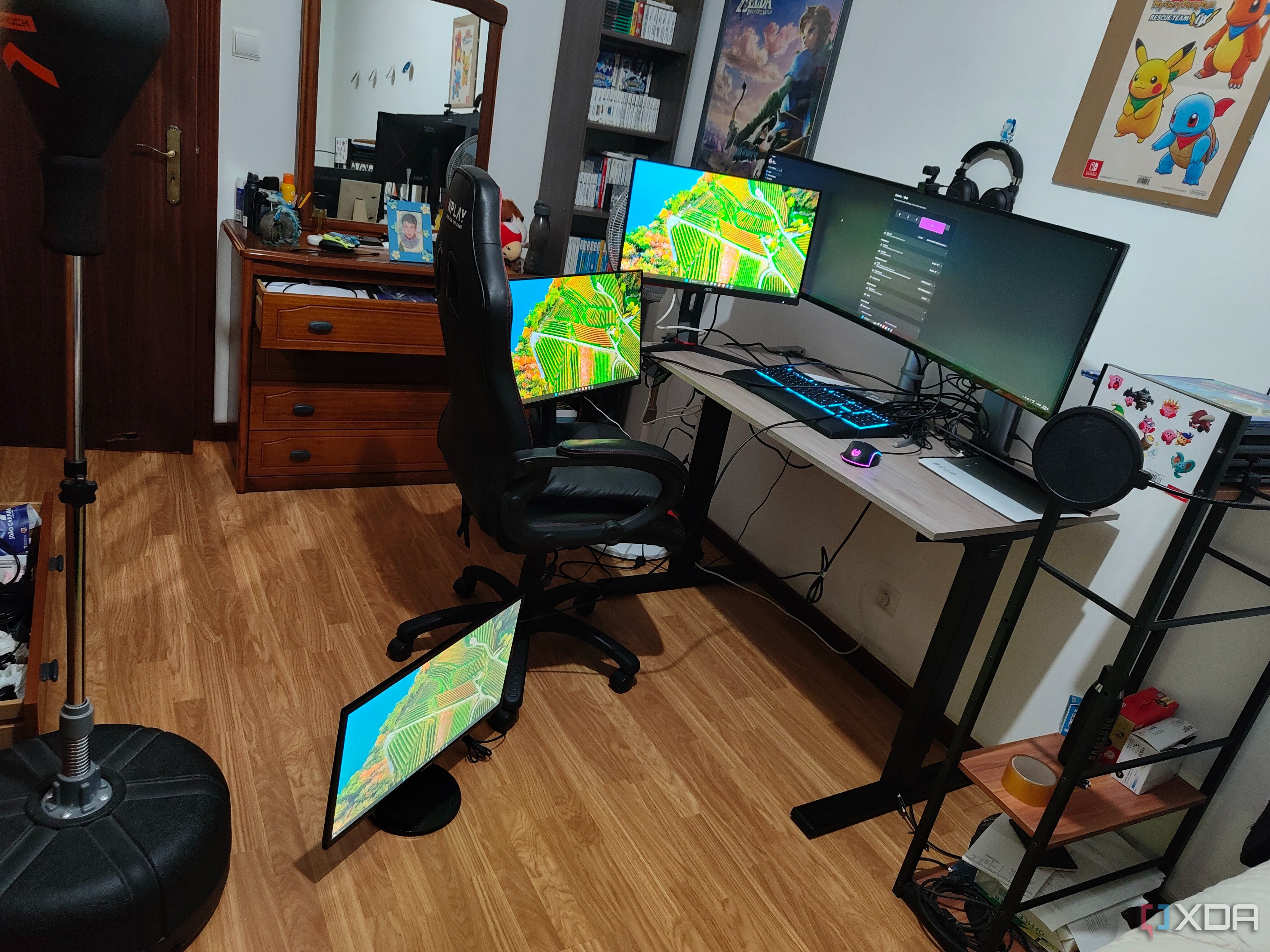 A computer desk with a laptop and four mopnitors on or arounds the desk, all connected to a dock, which is connected to a laptop. All the monitors are displaying the Windows 11 desktop