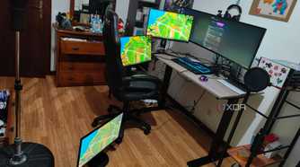 A computer desk with a laptop and four mopnitors on or arounds the desk, all connected to a dock, which is connected to a laptop. All the monitors are displaying the Windows 11 desktop