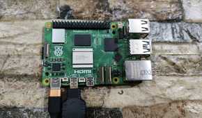 A Raspberry Pi 5 with a USB Type-C charging cable and a micro HDMI to HDMI adapter plugged in