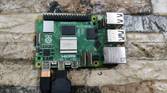 A Raspberry Pi 5 with a USB Type-C charging cable and a micro HDMI to HDMI adapter plugged in