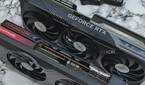 An image showing a GeForce RTX 4070 Ti and Radeon 7700XT GPUs kept on a table next to a split keyboard.