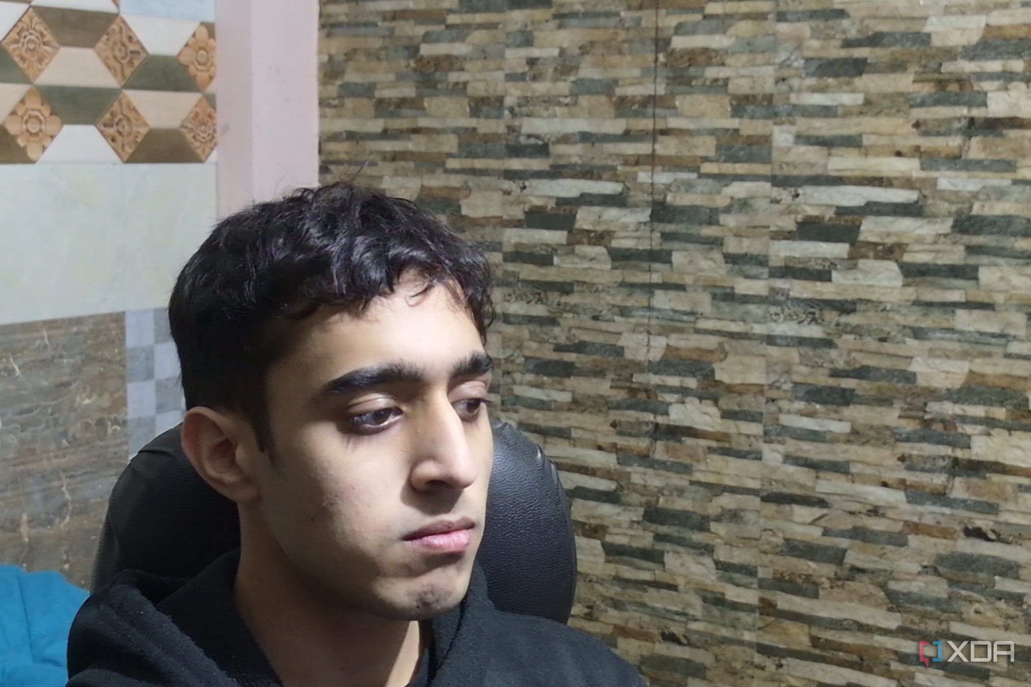 An image of a man sitting far away from the OBSBOT Tail Air webcam