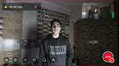 A mobile screenshot of a man standing in front of the OBSBOT Tail Air webcam