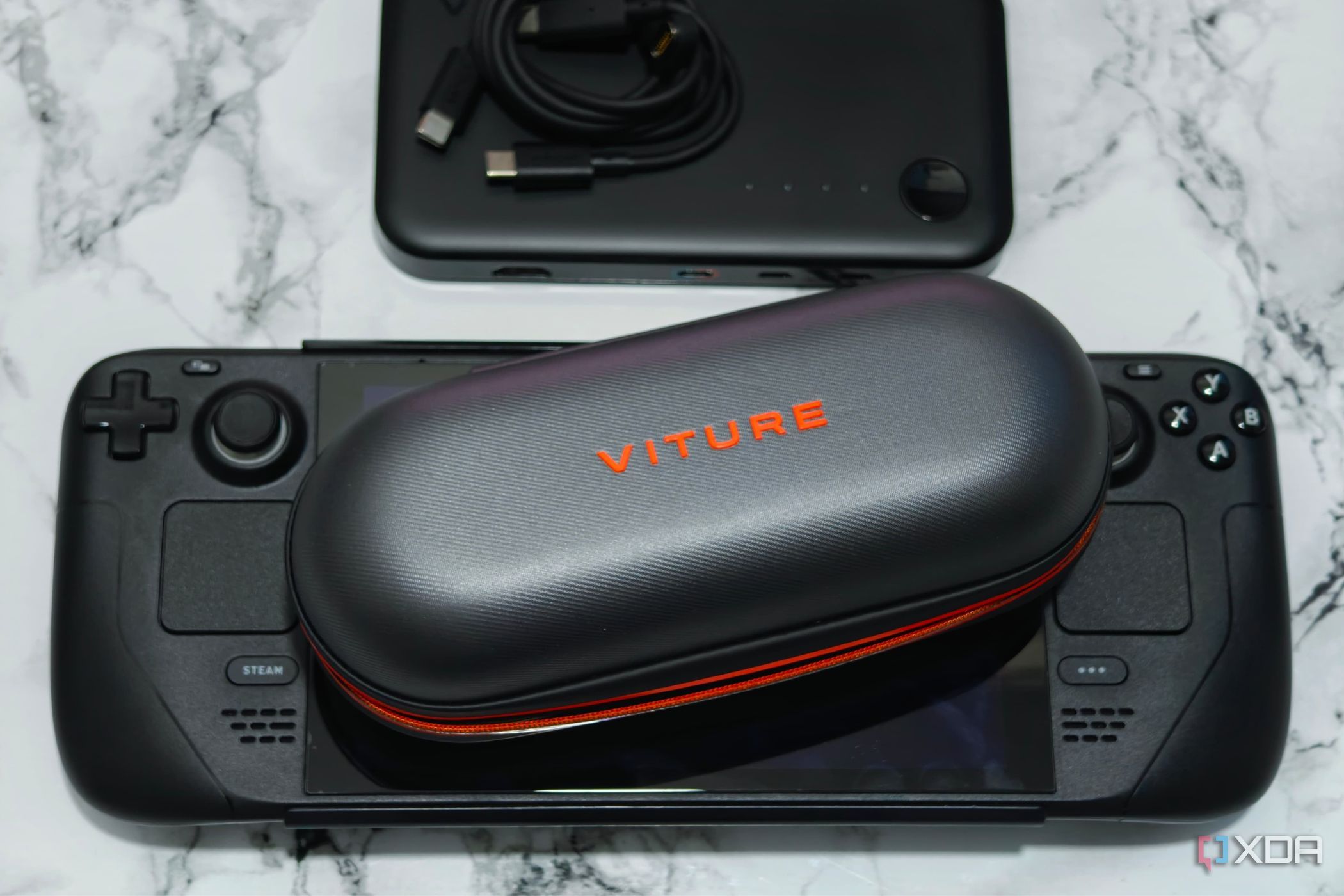 An image showing Viture smart glasses placed on a Steam Deck next to a dock.
