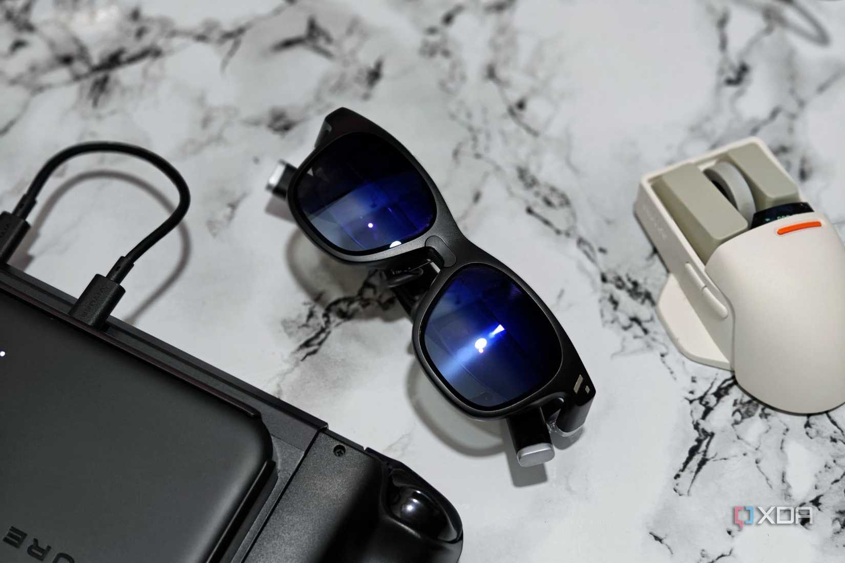 An image showing the Viture One glasses kept next to ta mouse and Steam Deck.