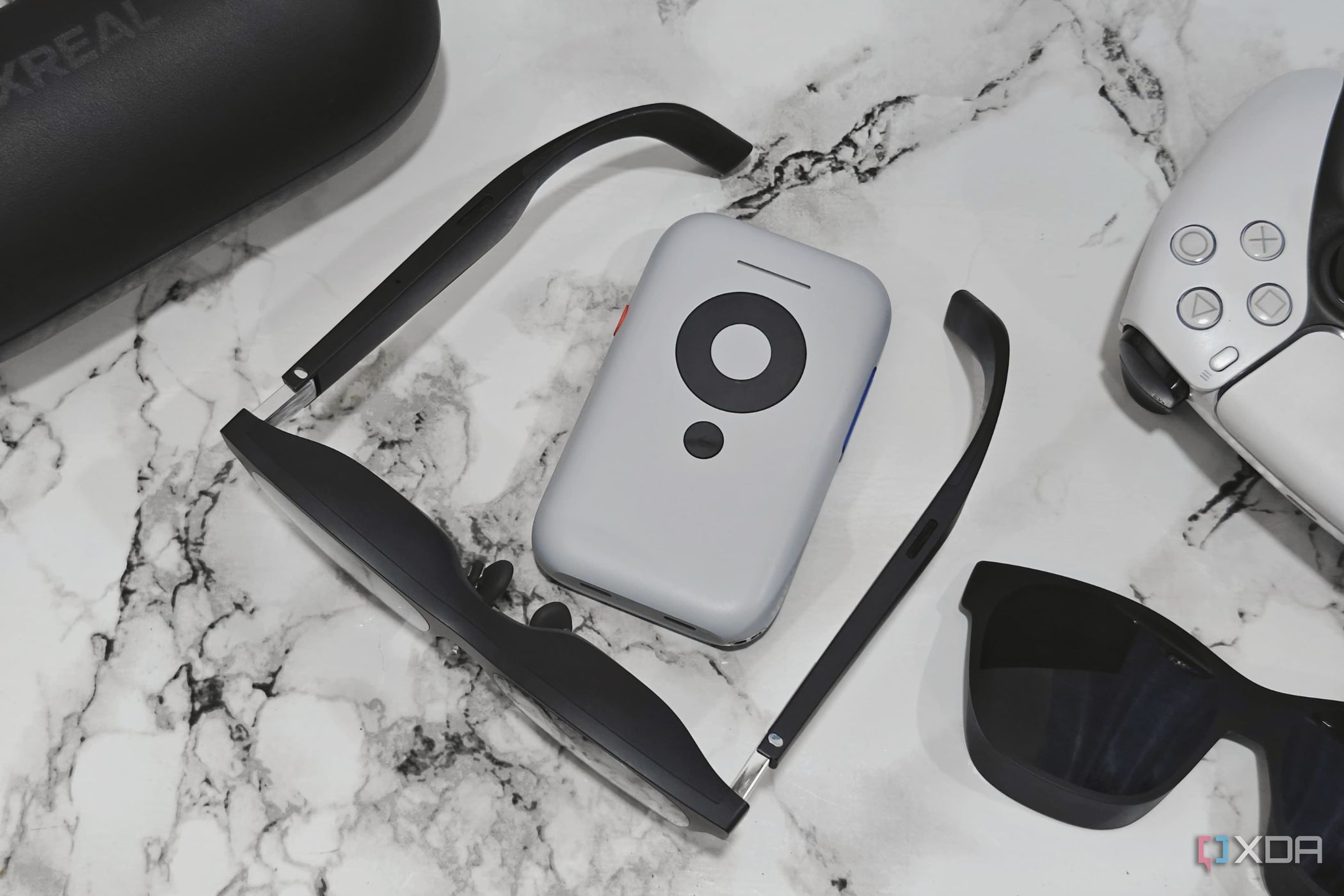An image showing the XREAL Air 2 glasses sitting next to the Beam accessory.
