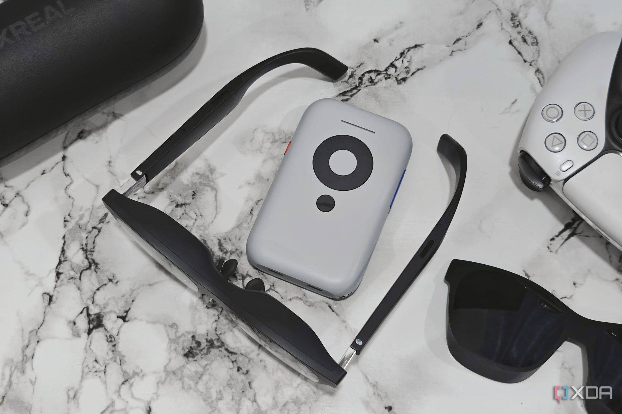 An image showing the XREAL Air 2 glasses sitting next to the Beam accessory.