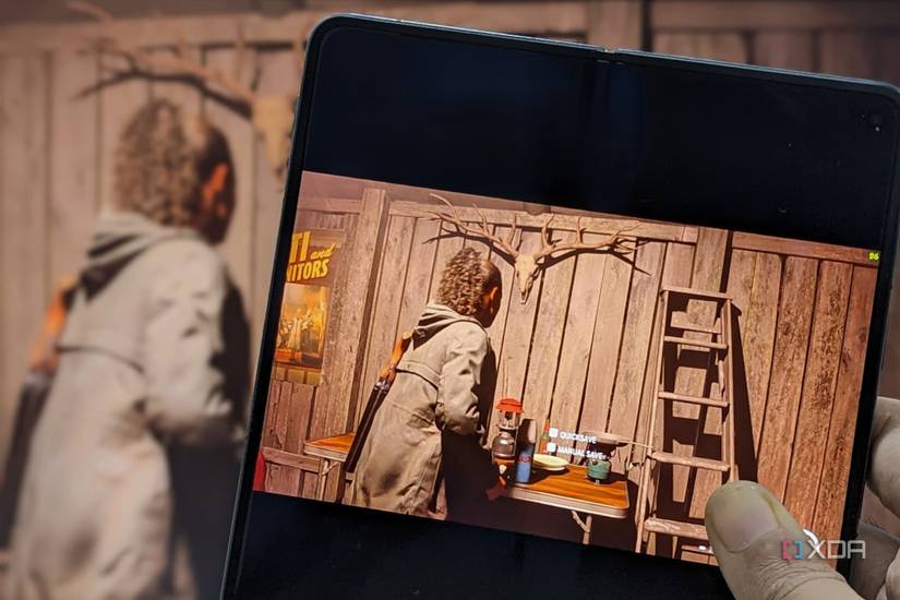 An image showing a phone running Alan Wake 2 with the same gameplay in the background.