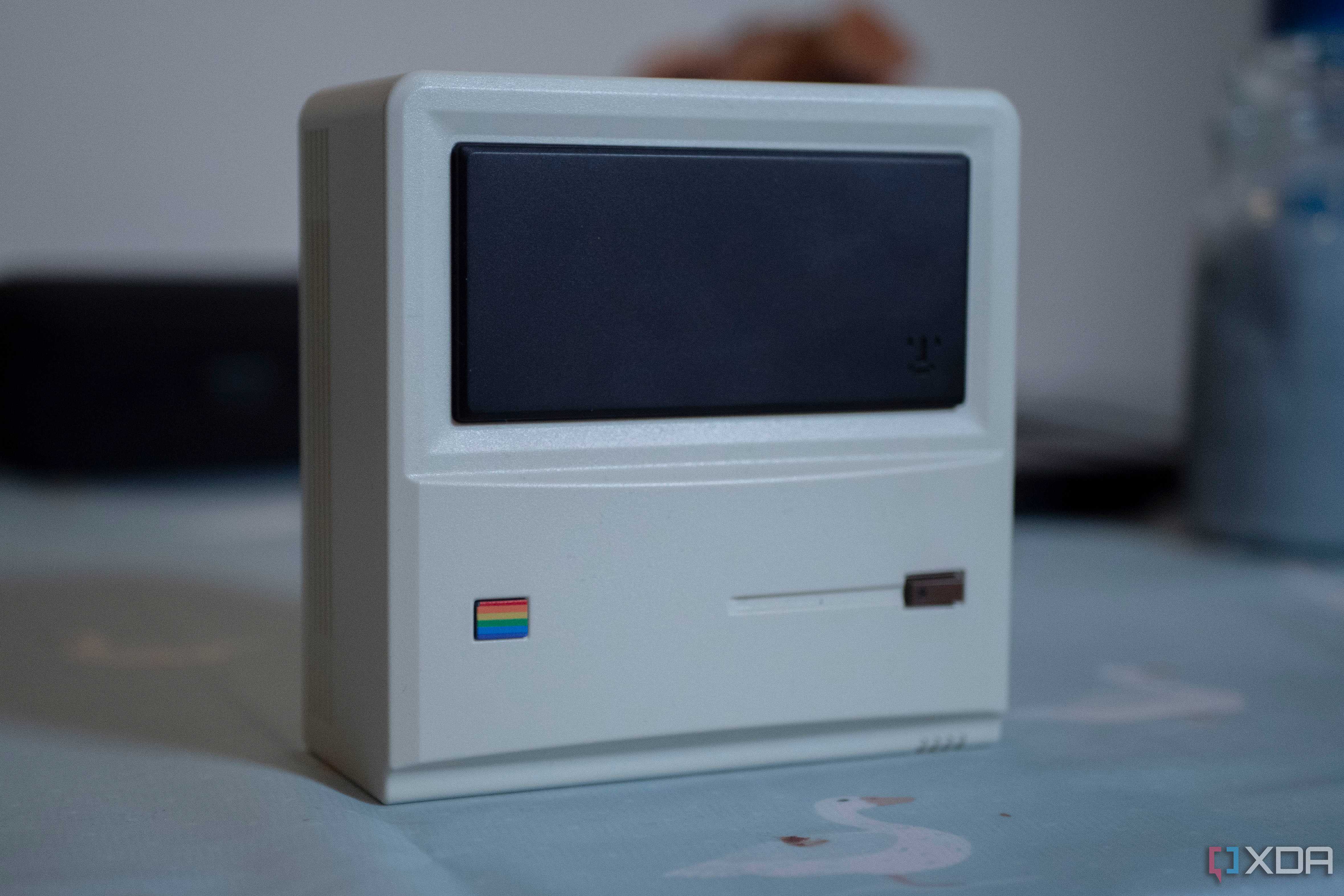 Ayaneo Retro Mini PC AM01 face up on a table, with a candle in the background