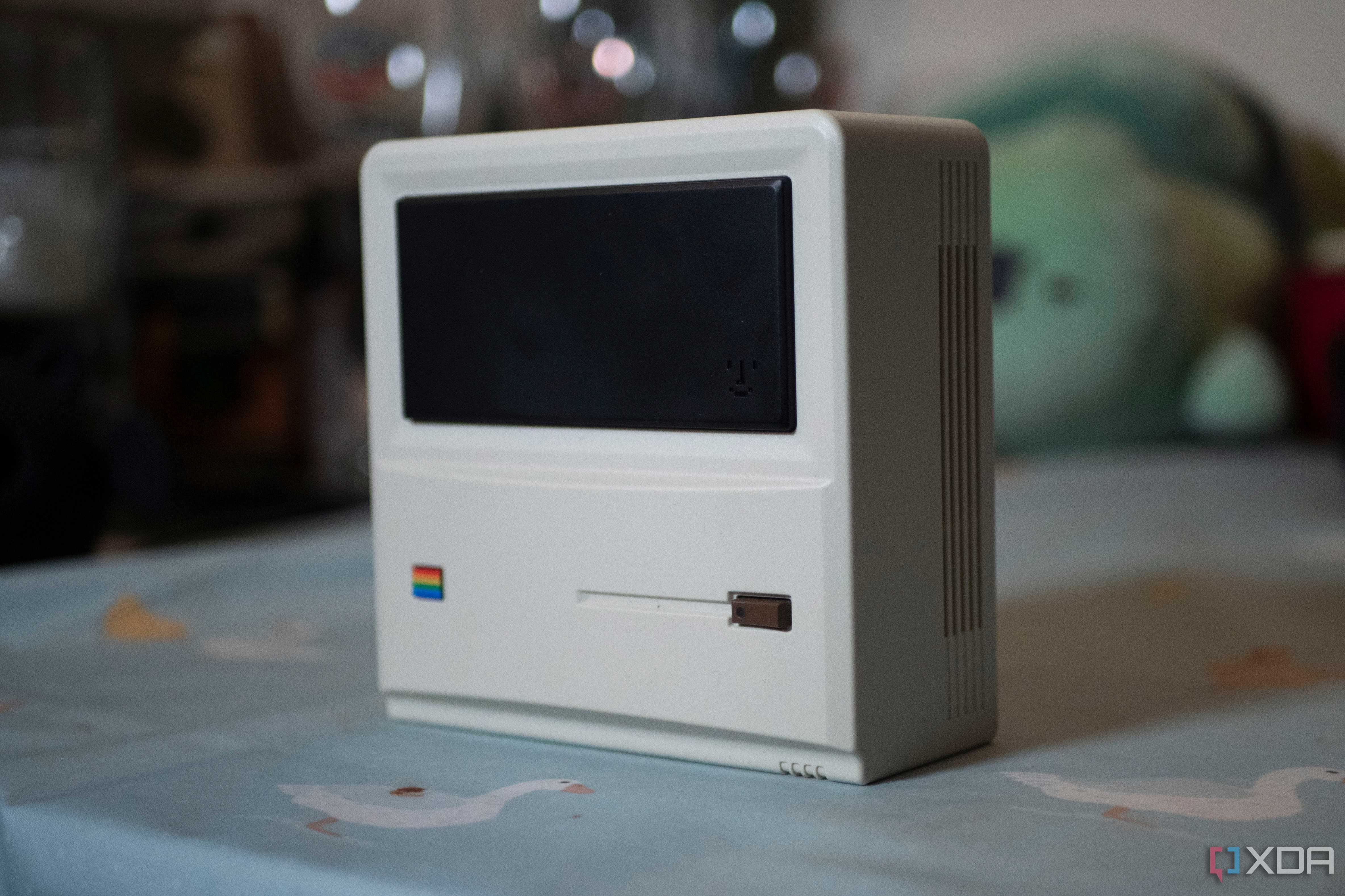 The front and side of the Ayaneo AM01 Retro Mini PC, standing upright on a table