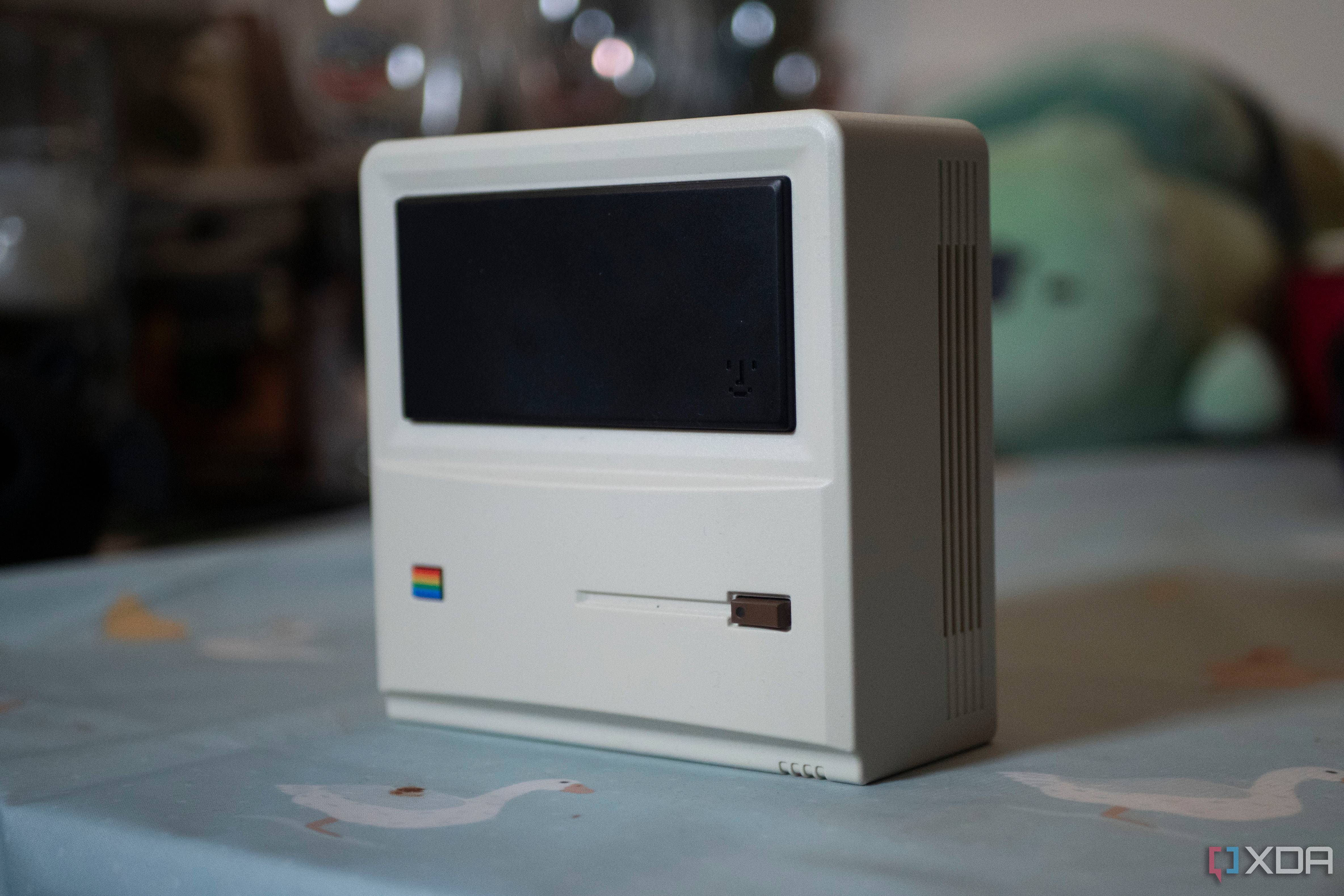The front and side of the Ayaneo AM01 Retro Mini PC, standing upright on a table