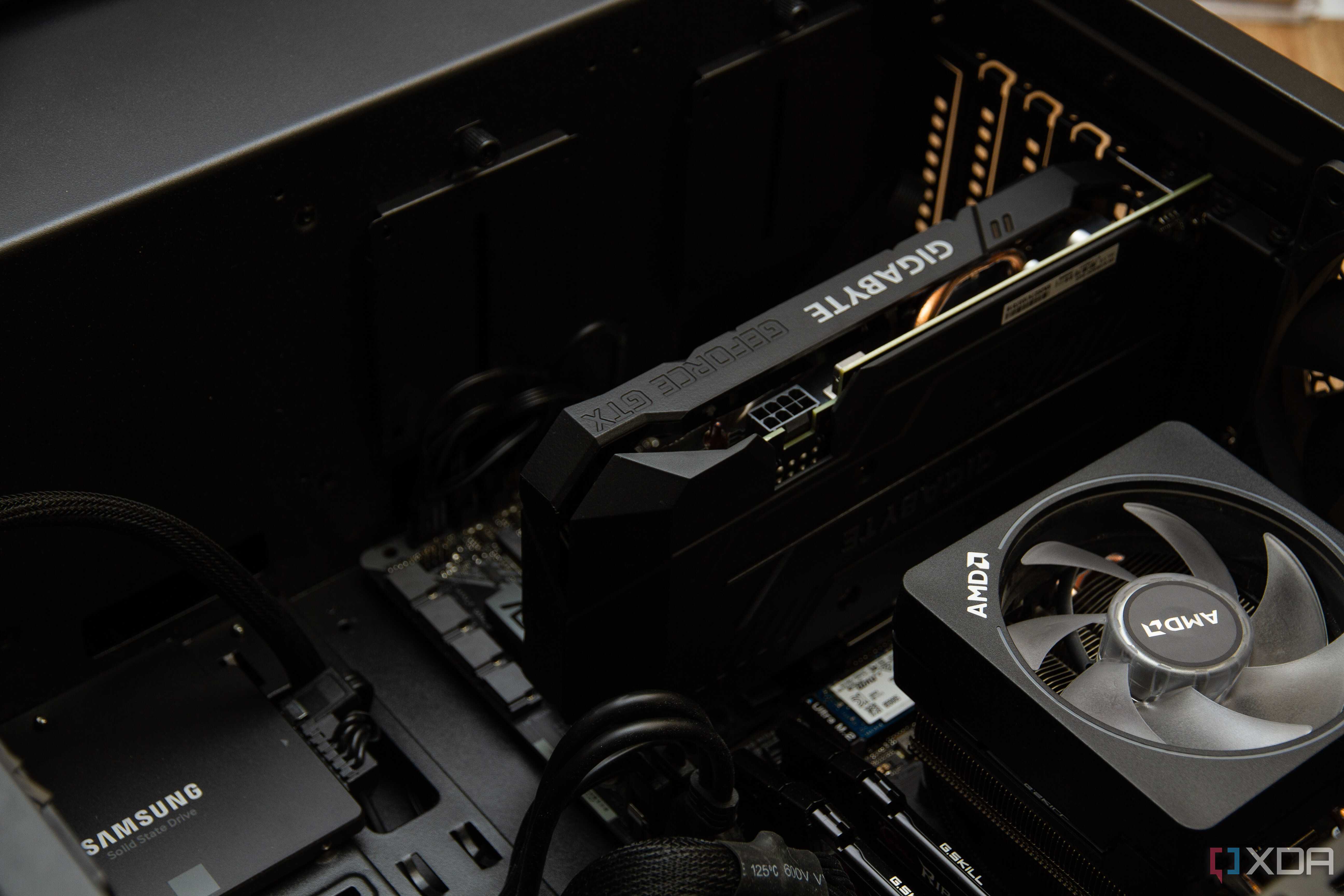 An open pc case, with a Gigabyte graphics card installed next to an AMD CPU heatsink and a Samsung SSD.