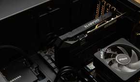 An open pc case, with a Gigabyte graphics card installed next to an AMD CPU heatsink and a Samsung SSD.