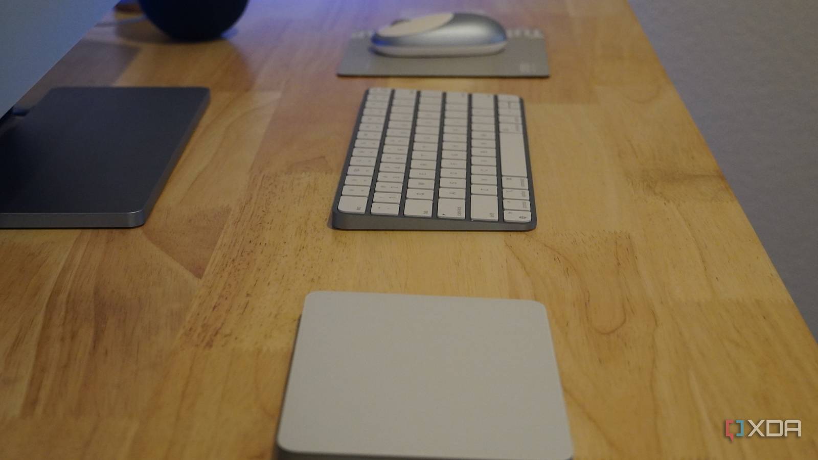 Three peripherals on a desktop: a keyboard, mouse, and trackpad.
