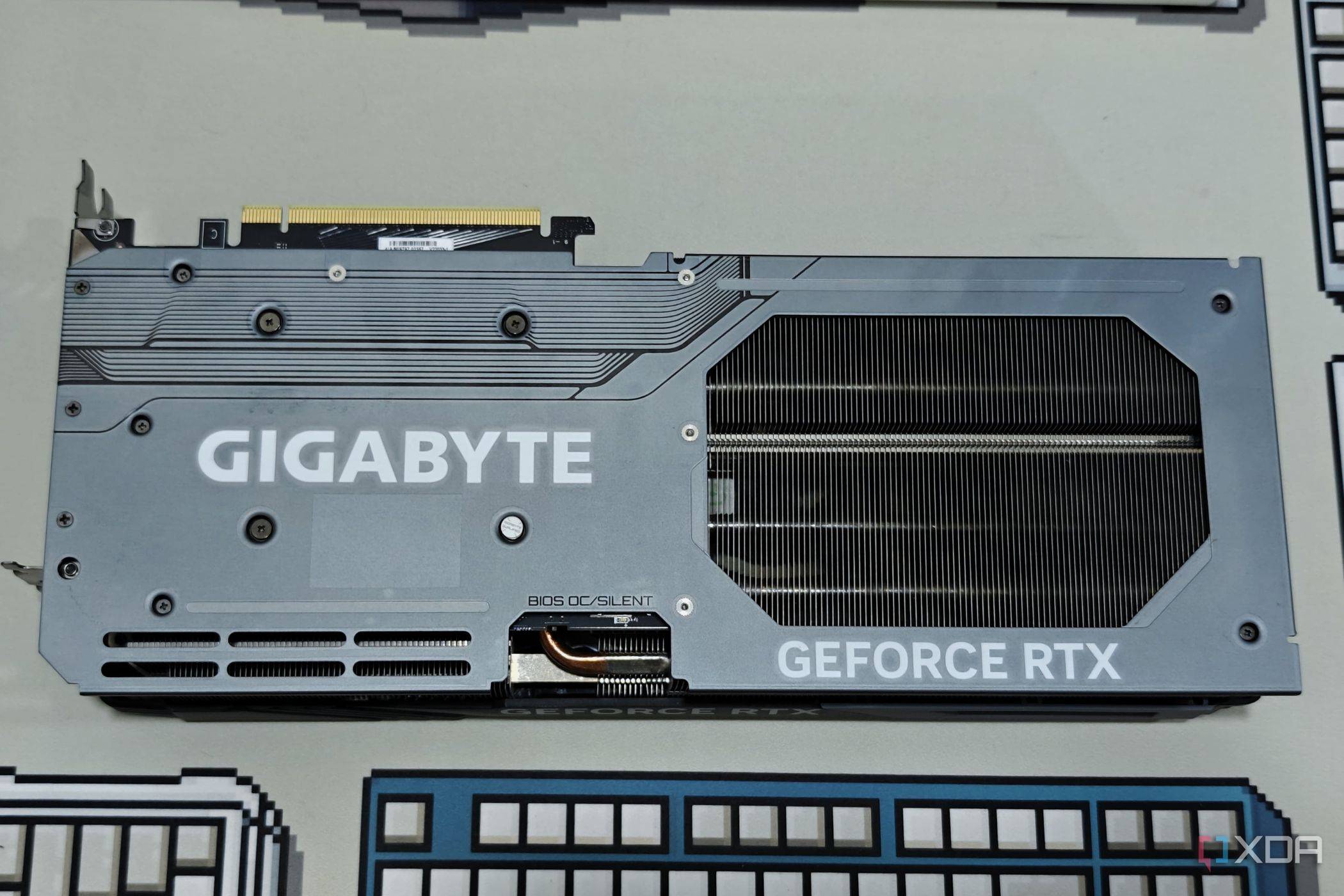 An image showing the backplate of a Gigabyte GeForce RTX 4070 Ti Gaming OC GPU that's kept on a deskmat.