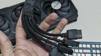 An image showing a person holding a 12VHPWR adapter cable in hand with the Gigabyte GeForce RTX 4070 Ti Gaming OC GPU in the background.