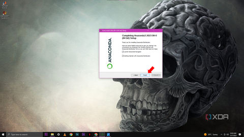 A screenshot of the final step in the Anaconda3 setup process with a "Completing Anaconda3 2023.09 (64-bit) Setup" message, checkboxes for launching the Anaconda Navigator and viewing getting started documentation, and a red arrow pointing to the "Finish" button.