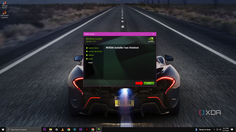A screenshot of the NVIDIA Installer window displaying a message that "NVIDIA Installer has finished" with a red arrow pointing to the "Close" button.