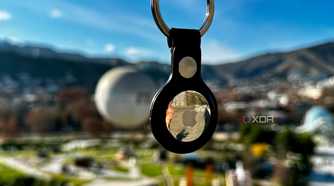 floating Apple AirTag keychain with greenery in the background
