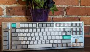 A Lemokey L3 stood up in front of a brick wall and a vase