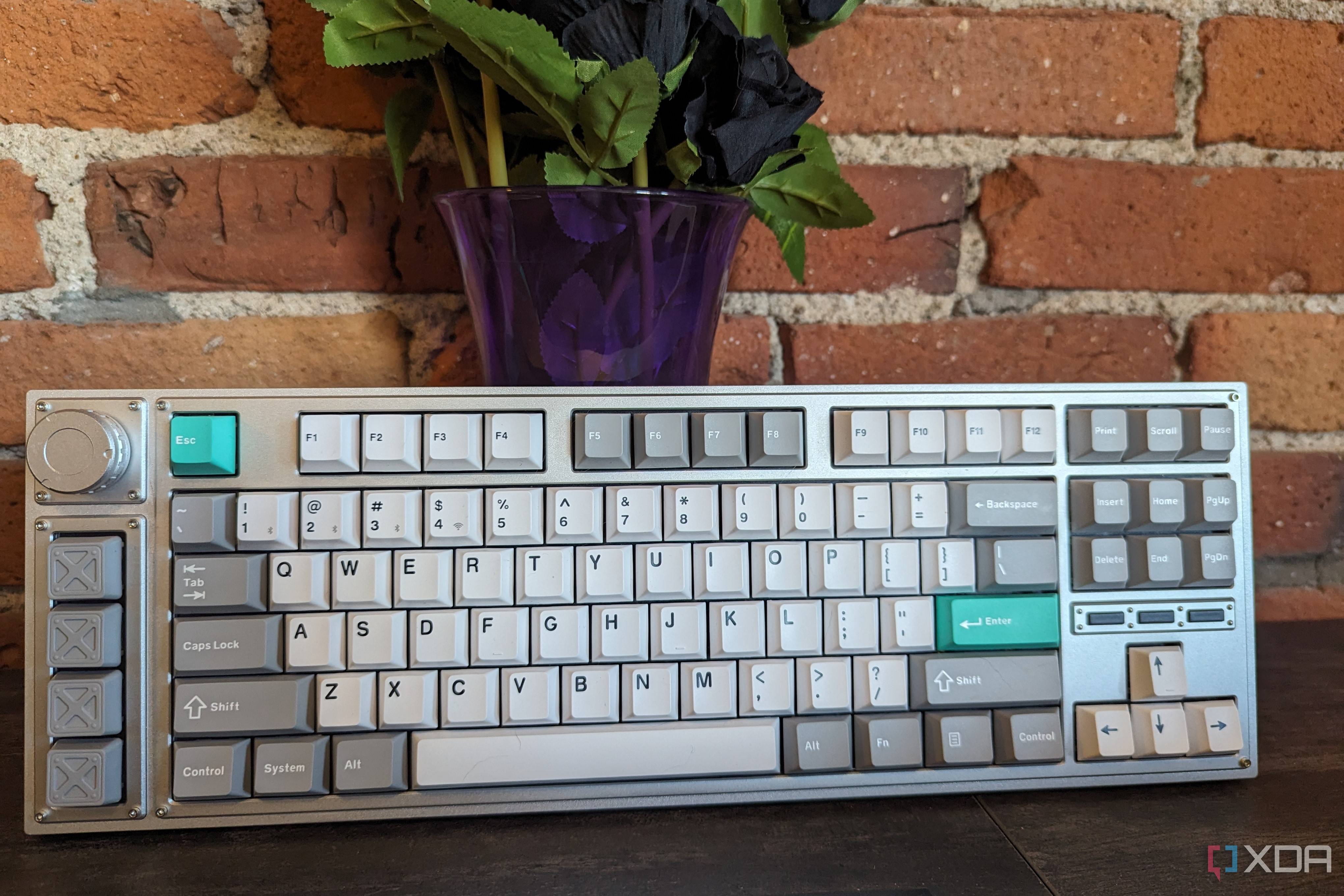 A Lemokey L3 stood up in front of a brick wall and a vase