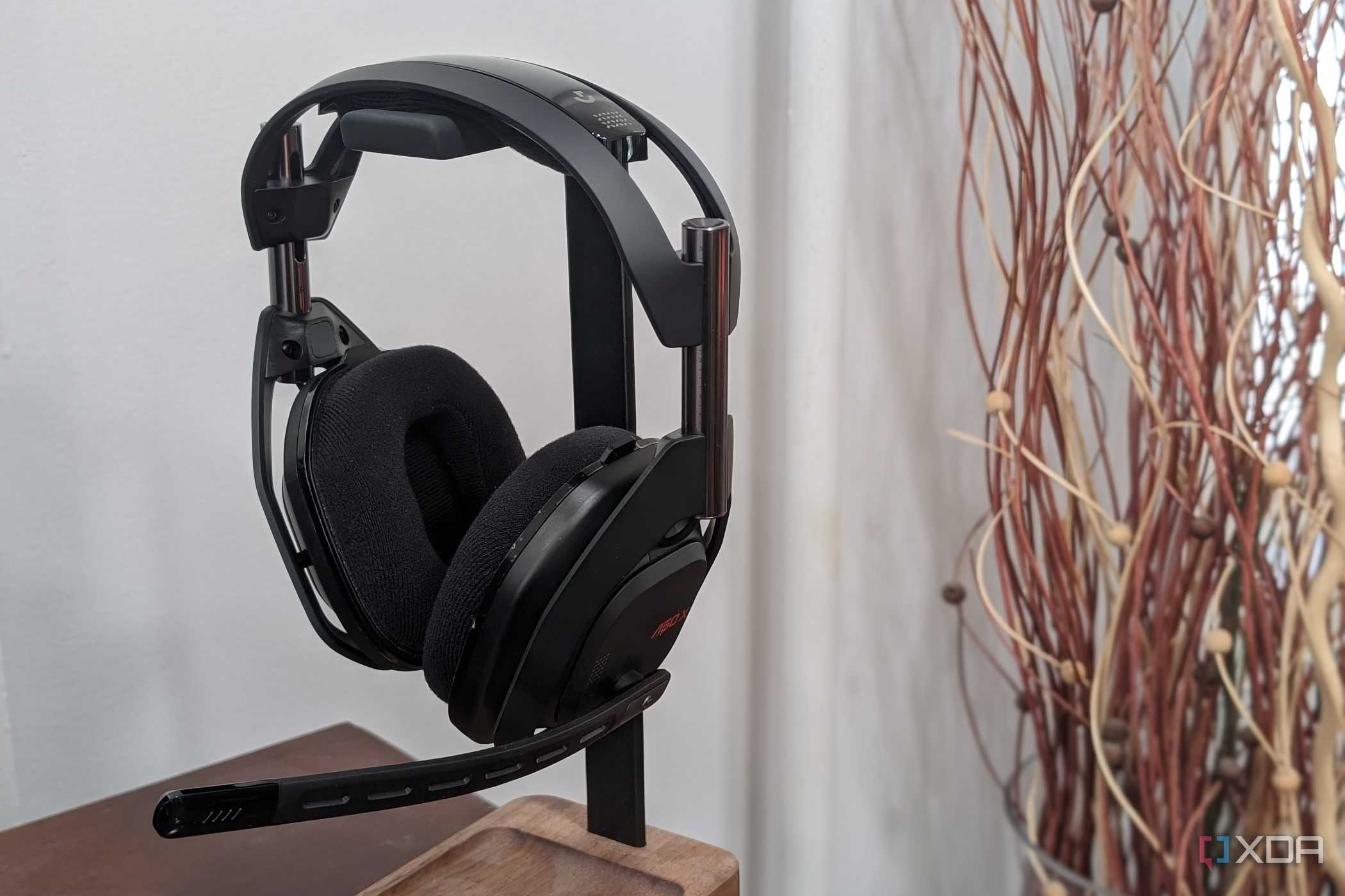 A photo of the Logitech G Astro 50 X Lightspeed sitting on a holder with a plant in the background